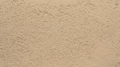 Finition de façade en enduit taloché beige, à l’aspect lisse et légèrement structuré, réalisée à la taloche pour un rendu uniforme et soigné.